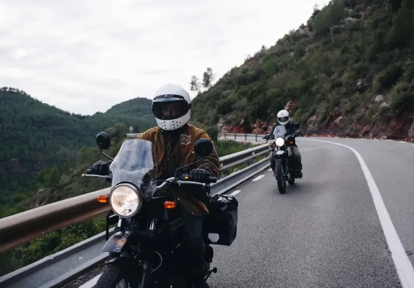 Pengendara motor beristirahat sambil mengonsumsi makanan pedas saat touring